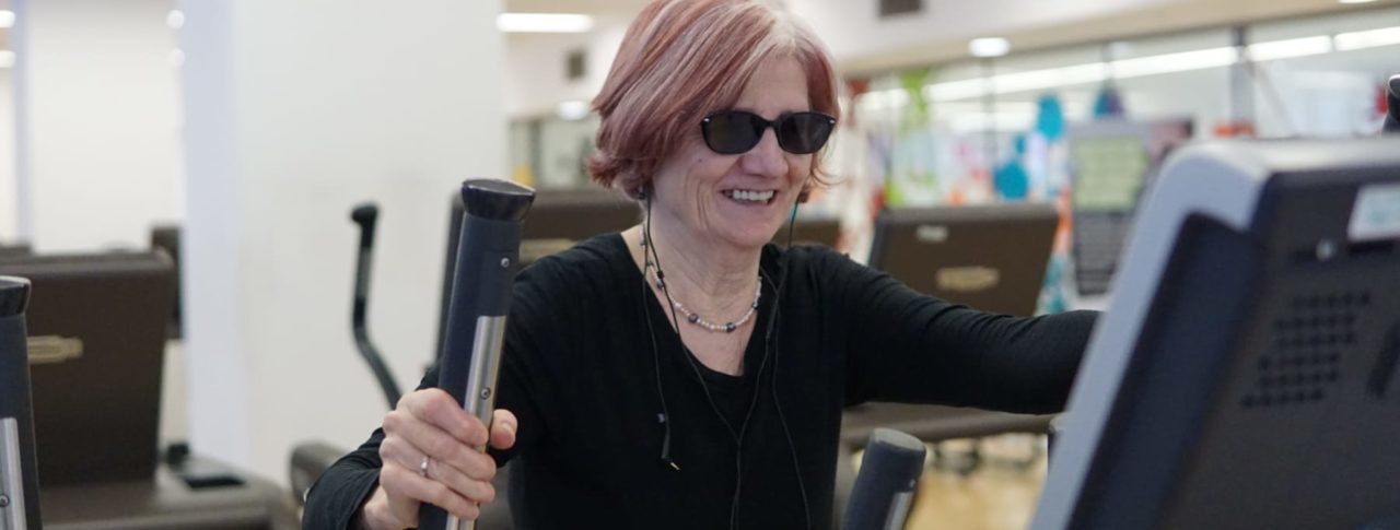 Image of blind person enjoying exercise on a treadmill in a gym