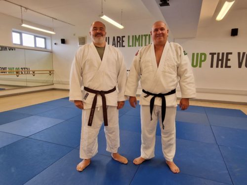 Ian Sidaway, Head Coach from Knottingley Judo Club (right), is pictured with Sight Loss Council member Simon Sharp. They are standing next to each other on the Judo mat, smiling at the camera.