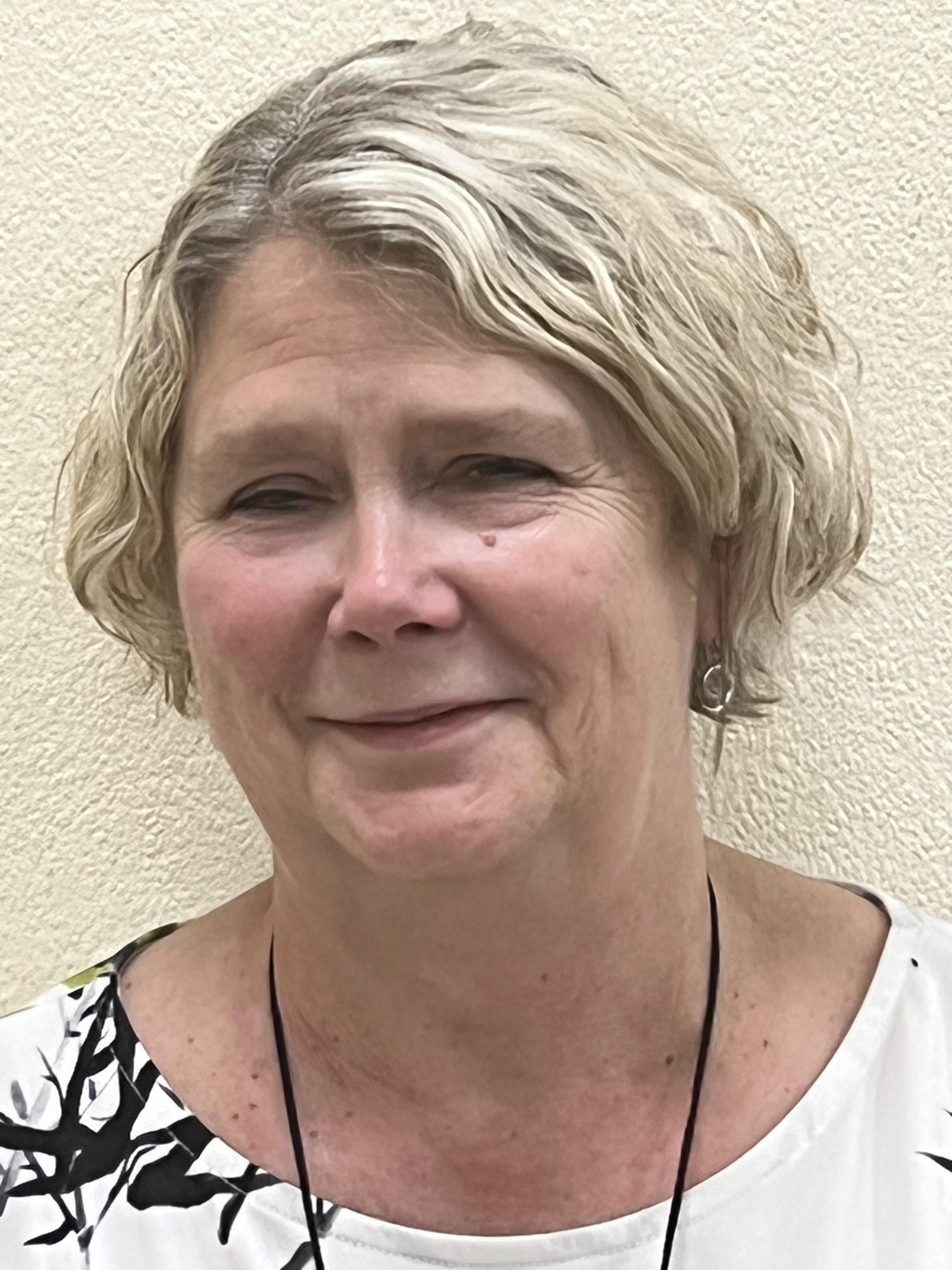 Head shot of Gill Currie. she has jaw length, fair hair. She is smiling at the camera.