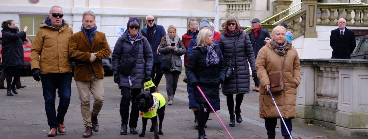 Councillors navigating the streets of Southport town centre wearing spectacles (sim specs), with Sight Loss Council members.