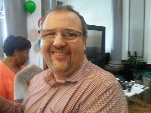 Headshot of Emanuel Beck, London SLC member. He is facing the camera, smiling,
