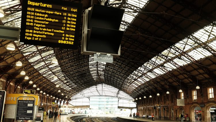 The interior of Bristol Station with a departure board.