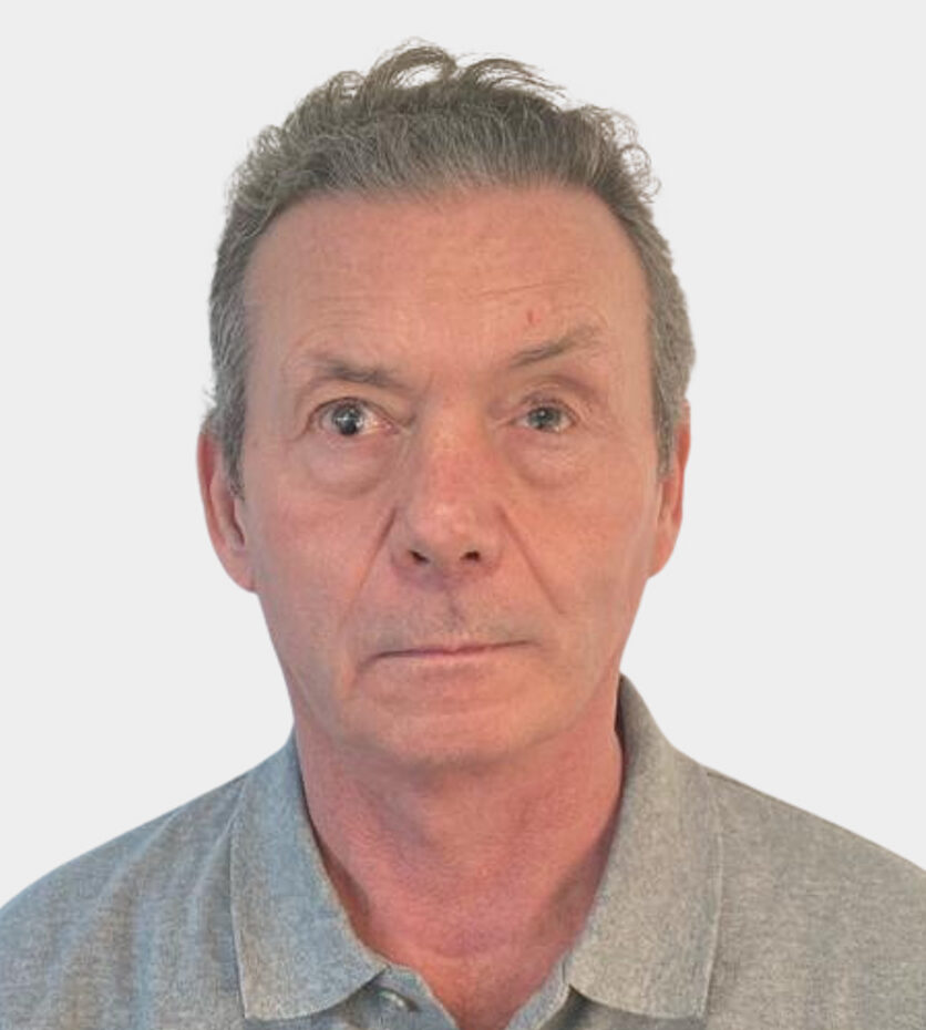 Paul Hatfield headshot. Paul is wearing a grey polo shirt, standing against a white background and smiling at the camera.