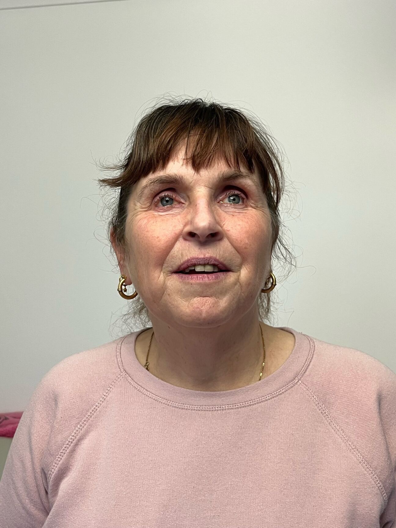 Alison Evans headshot. Alison has short dark hair and is wearing a light pink t-shirt. She is smiling at the camera.