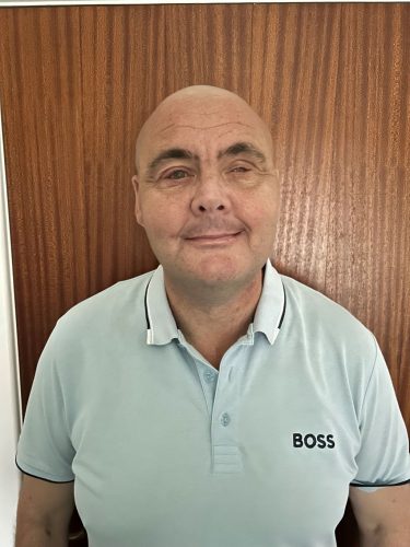 Lee Roberts headshot. Lee is wearing a white polo shirt and is smiling at the camera.