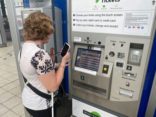 Sussex SLC member Linn Davies is guided to a ticket machine at Brighton station using the Aira App.