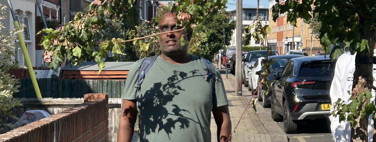 South West London SLC member pictured walking into an overhanging tree branch with his guide dog.