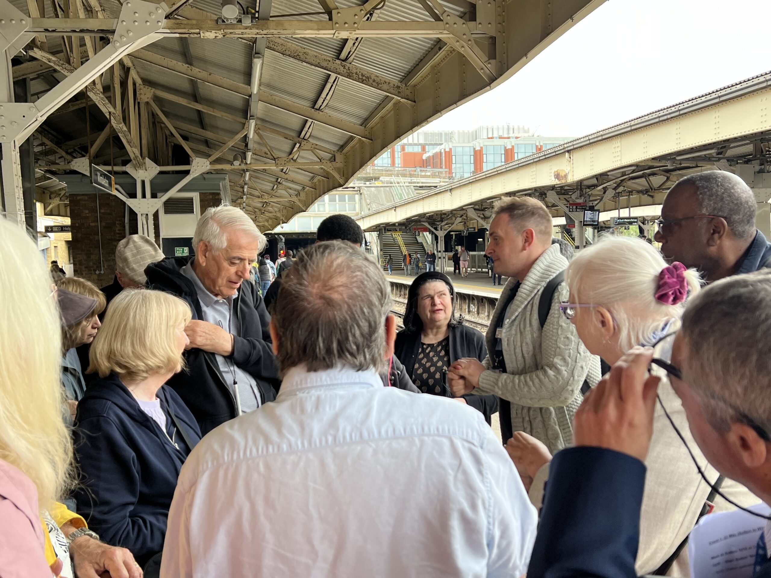 Mike Addington, Accessibility Engagement Manager for SW Railway, is addressing attendees on a platform at Wimbledon train station during a previous TaT event.