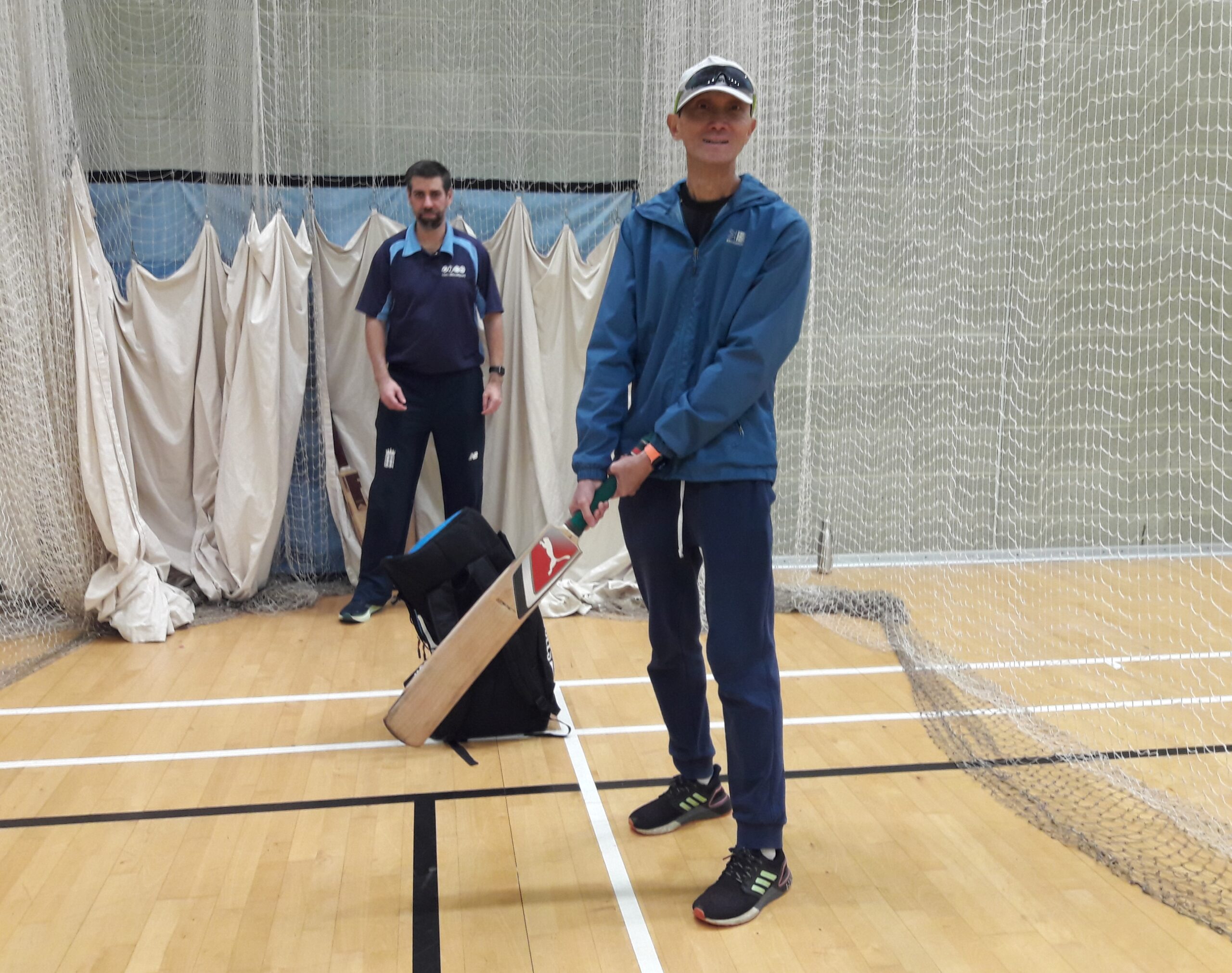 Paul, North London SLC member, poised to bat. A coach is behind him, ready to catch the ball.