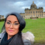 Selfie style photos of Vicky thompson, SLC Coordinator for Yorkshire and Humberside. She has long, dark hair and is wearing glassed. She is stood outside on a lawn, in front of a historical building. The sky is black.