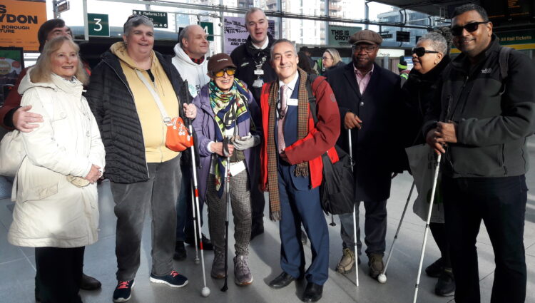 A group shot of everyone standing in the entrance hall at East Croydon station posing for the camera