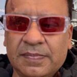 Headshot of Paresh Jotangia, North London SLC member. Paresh has short dark hair and wearing rose-tinted glasses with a clear frame.