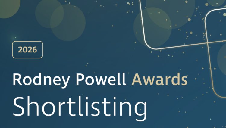 Graphic banner with a dark blue gradient background featuring soft, translucent circular shapes and scattered gold dots. On the left, a gold‑outlined rounded rectangle contains the text “2026.” Large white and gold text reads “Rodney Powell Awards,” with “Shortlisting” displayed prominently below in white. Decorative curved gold lines sweep across the right side, with a subtle glowing effect near the lower right corner, adding a celebratory, polished feel.