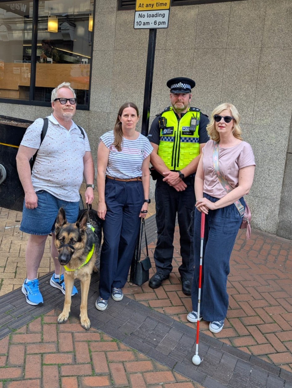 Steve, a BABC SLC member, with guide dog Rowley, stands with a West Midlands Police officer in uniform, a West Midlands police staff member, and Louise Connop, Senior Engagement Manager for TPT.