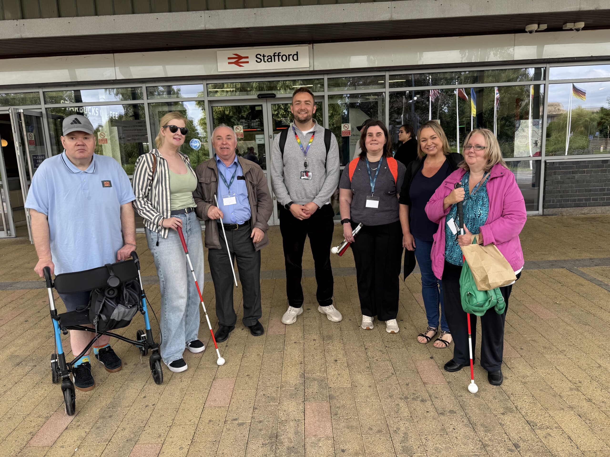 Members of Staffordshire Sight Loss Council stand outside Stafford railway station. From left to right: Ian, Louise Connop, Senior Engagement Manager, Geoff, Brandon Peat, Accessibility Lead at Avanti West Coast, Klaudia, Staffordshire SLC member, PJ, SLC Coordinator for the West Midlands, and Tanja, Staffordshire SLC member.