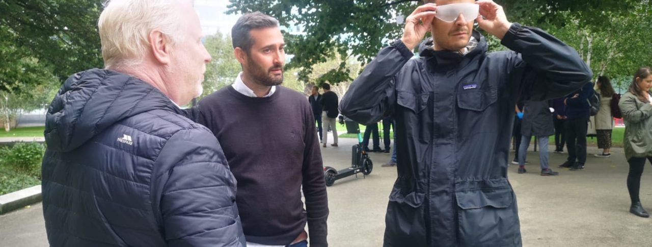 3 men in park consulting on use of e-scooters