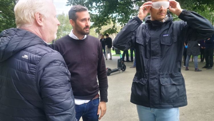 3 men in park consulting on use of e-scooters