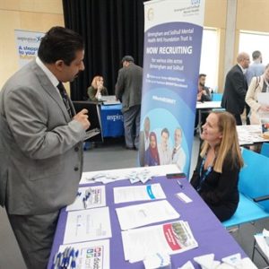 Male attendee talking o a female recruiter over a desk