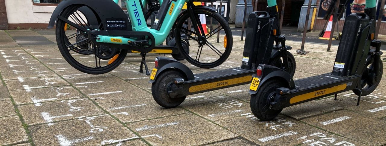 TIER e-scooters and e-bike parked in marked bay