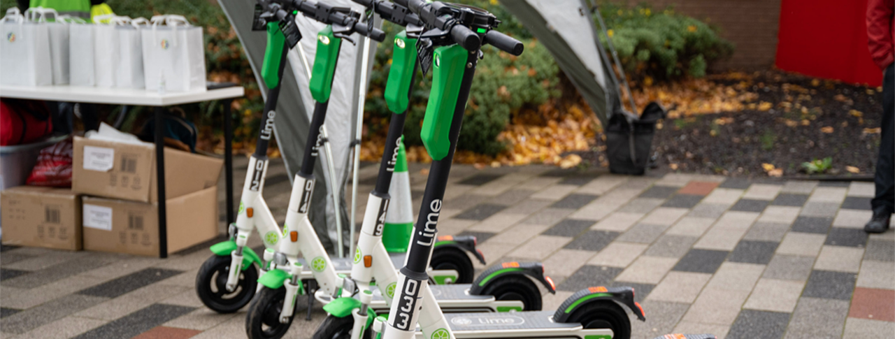 a row of 5 parked Lime e-scooters