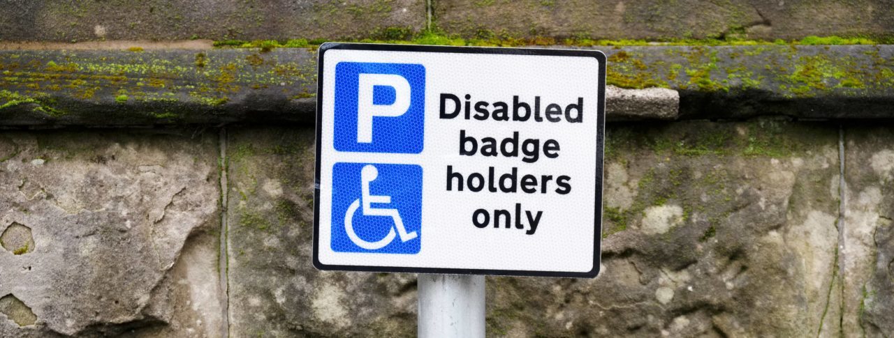 picture of a street sign that reads Disabled badge holders only