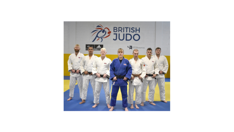 natalie standing at the front of 6 other judo teammates with the British logo in the background