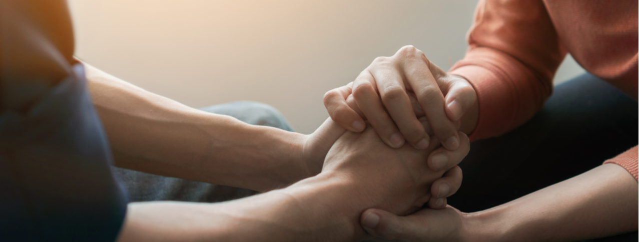 one person holding another persons hands offering support