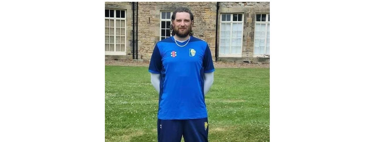 Jack Moffat standing on a green field wearing his Durham VI cricket kit