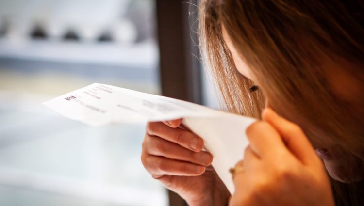 Partially sighted woman struggling to read hard copy letter from NHS