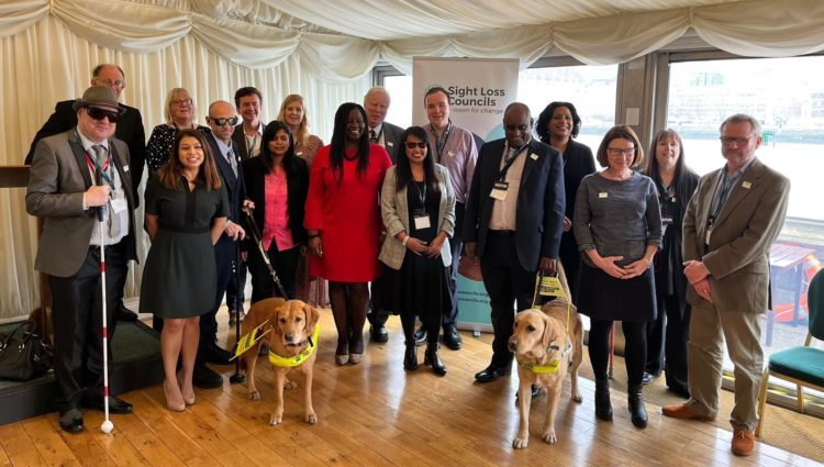 A large group photo of volunteers and MPs in Westminster.