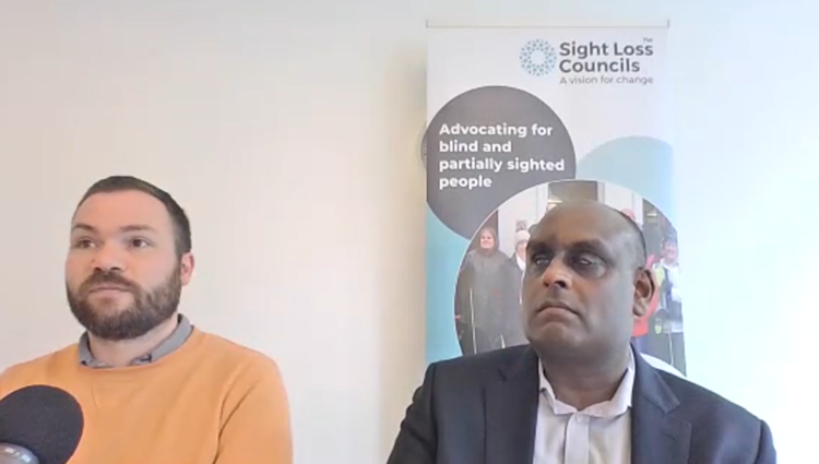 two speakers in a meeting room with Sight Loss Council banner in background