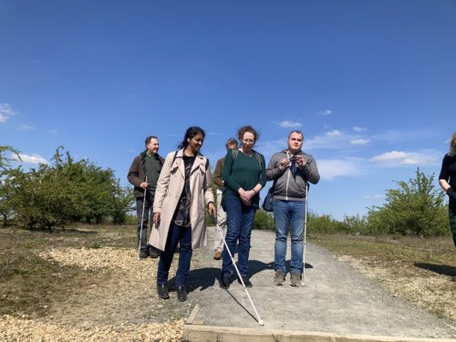 A group of people on a country path several of whom are white cane users