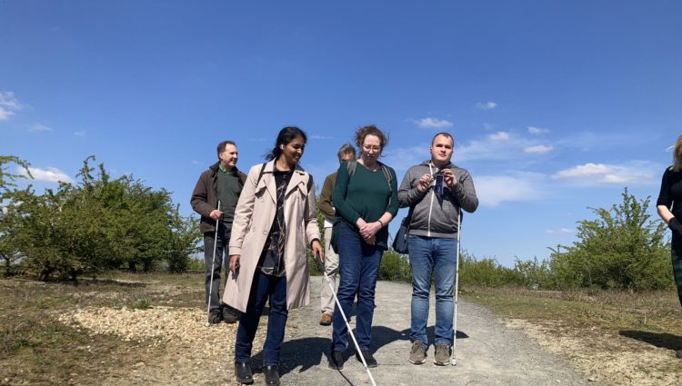 A group of people on a country path several of whom are white cane users