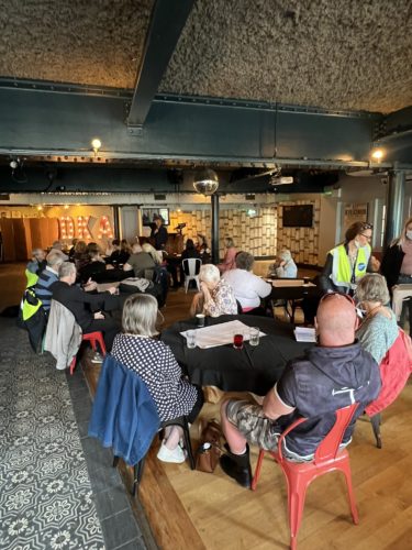 Gathering of people congregated around tables