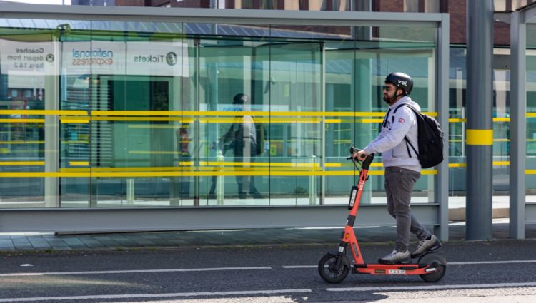 Voi e-scooter riding past Liverpool bus station