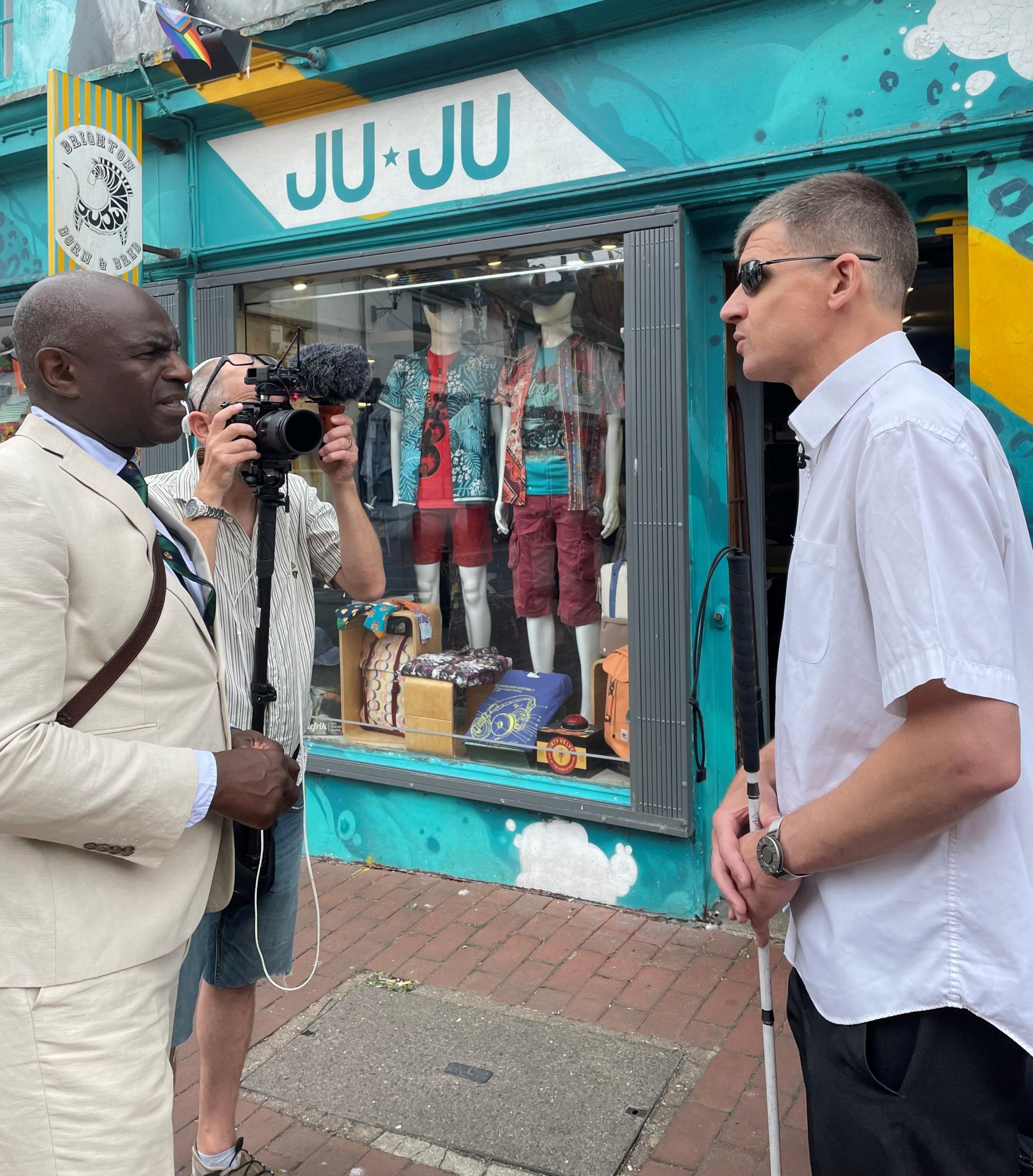 Dave Smith being interviewed. He is facing the news anchor Ian Palmer, there is a camera man holding up a camera and filming them to the side.