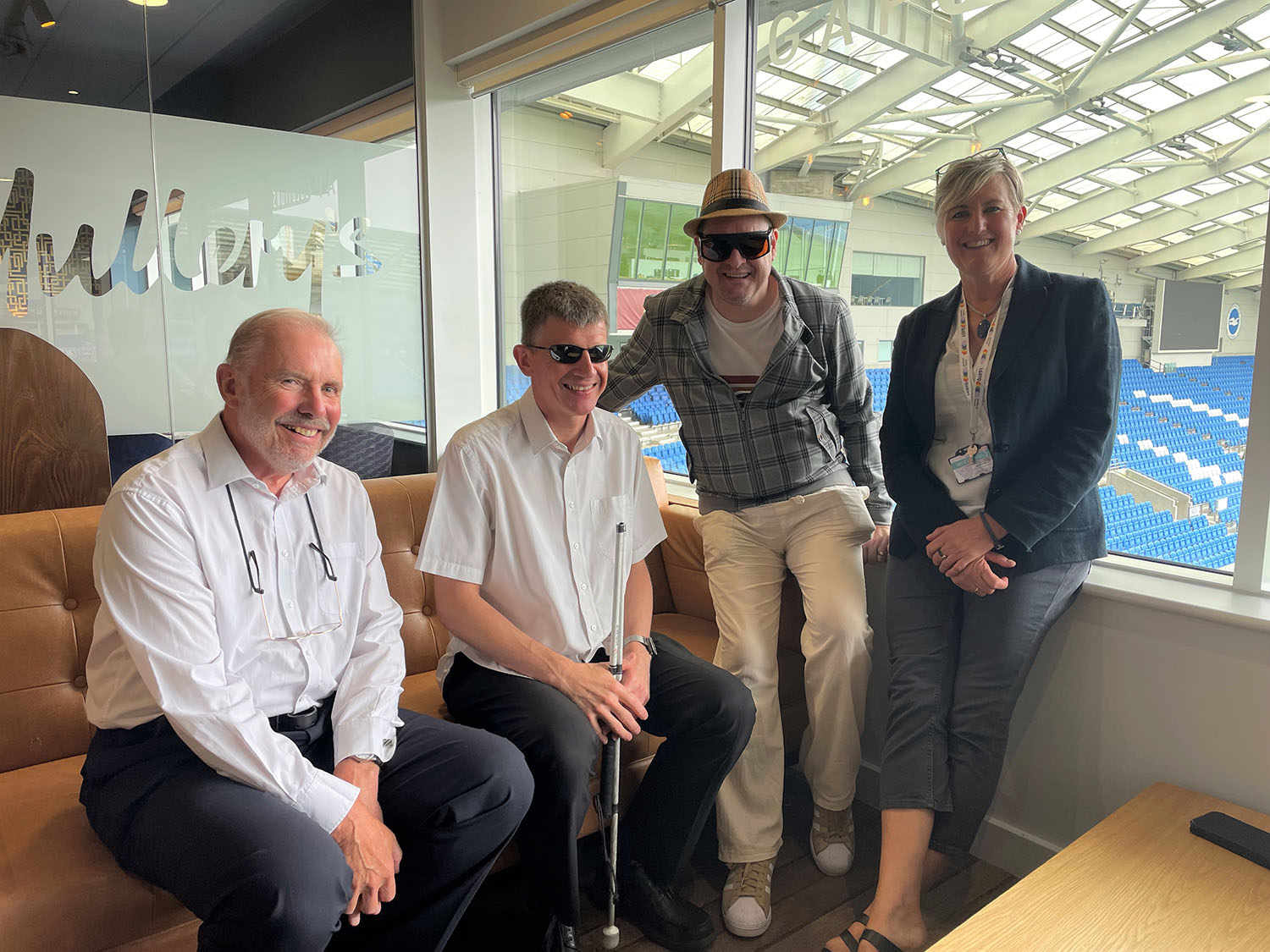 Left to right: Ian Palmer (BPS guest), Dave Smith, Paul Goddard and Shanni Collins from the Healthy Lifestyles team at Brighton & Hove City Council sitting by a window with the football stadium in the background. 