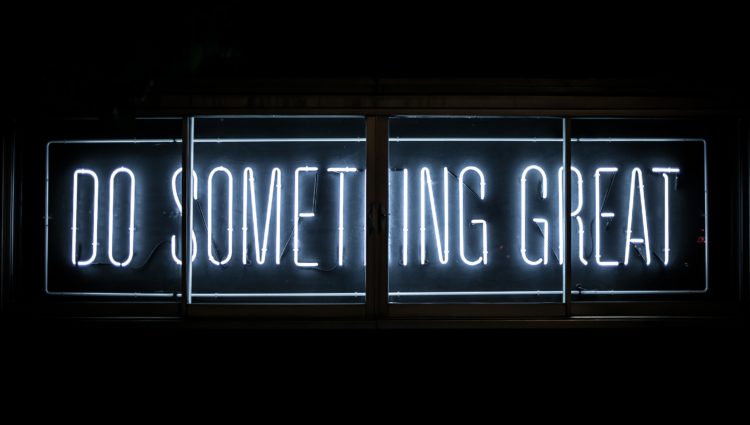 White neon text on a black background. The letters state: "Do something great".