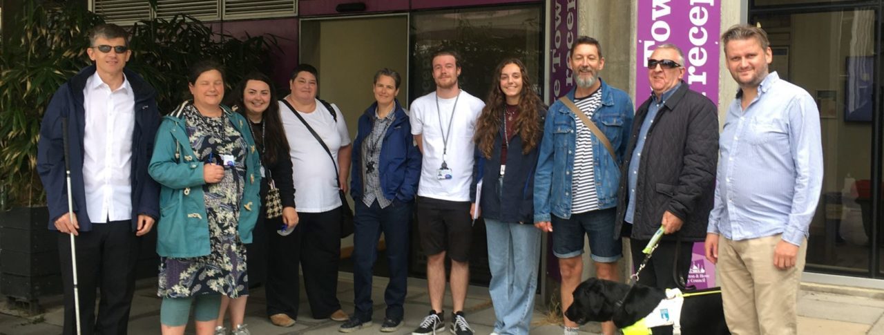 Group shot outside Hove Town Hall. From left to right: : Dave Smith, Lesley Heath, Jazmine Hayes, Iris Keppler, Michelle Jamieson, Jonathan Martin, Freya Woodhouse, Jez, Steve Saunders, guide dog Rosie and James Hammond.