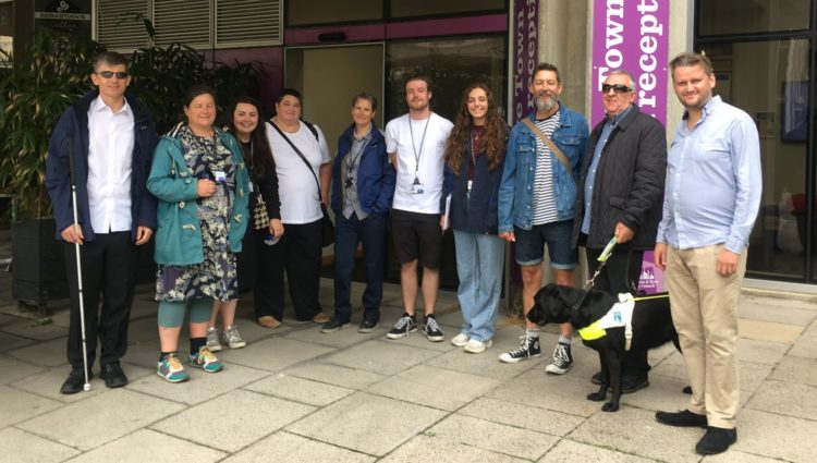 Group shot outside Hove Town Hall. From left to right: : Dave Smith, Lesley Heath, Jazmine Hayes, Iris Keppler, Michelle Jamieson, Jonathan Martin, Freya Woodhouse, Jez, Steve Saunders, guide dog Rosie and James Hammond.