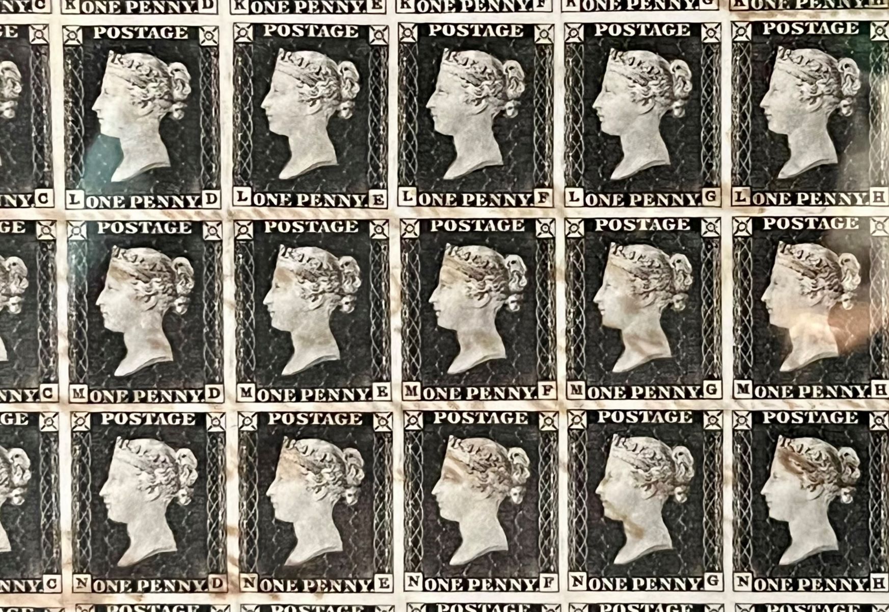 Image shows multiple 'Penny black' stamps, Queen Victoria is on them with the words 'One Penny' across the bottom
