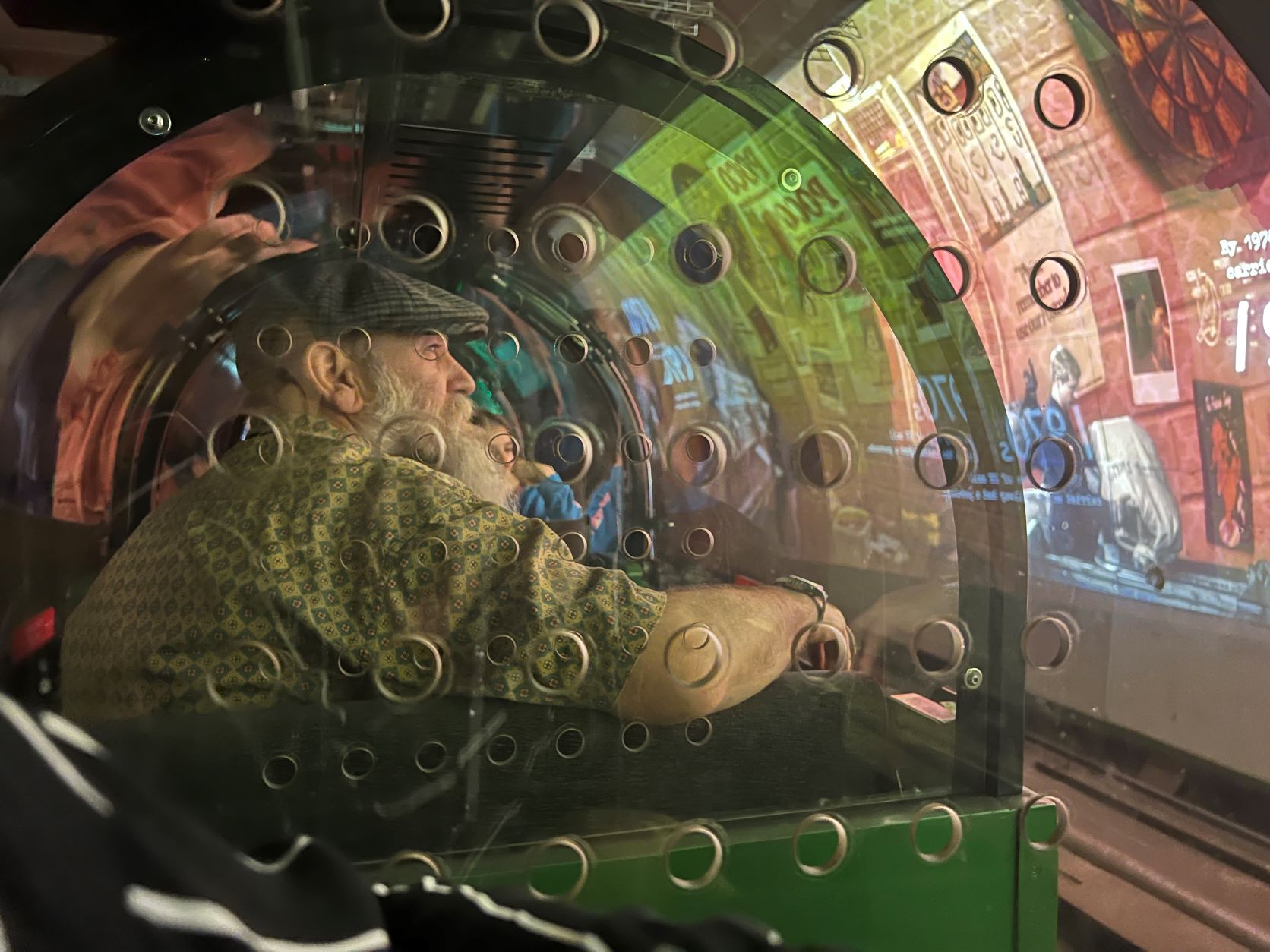 One of the attendees sitting in a carriage whilst on Mail Rail. He is looking at the displays being projected onto the walls of the tunnel.