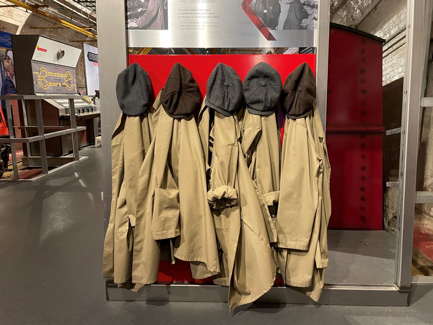 Image of the old postal workers brown jackets and caps hanging up in a row.