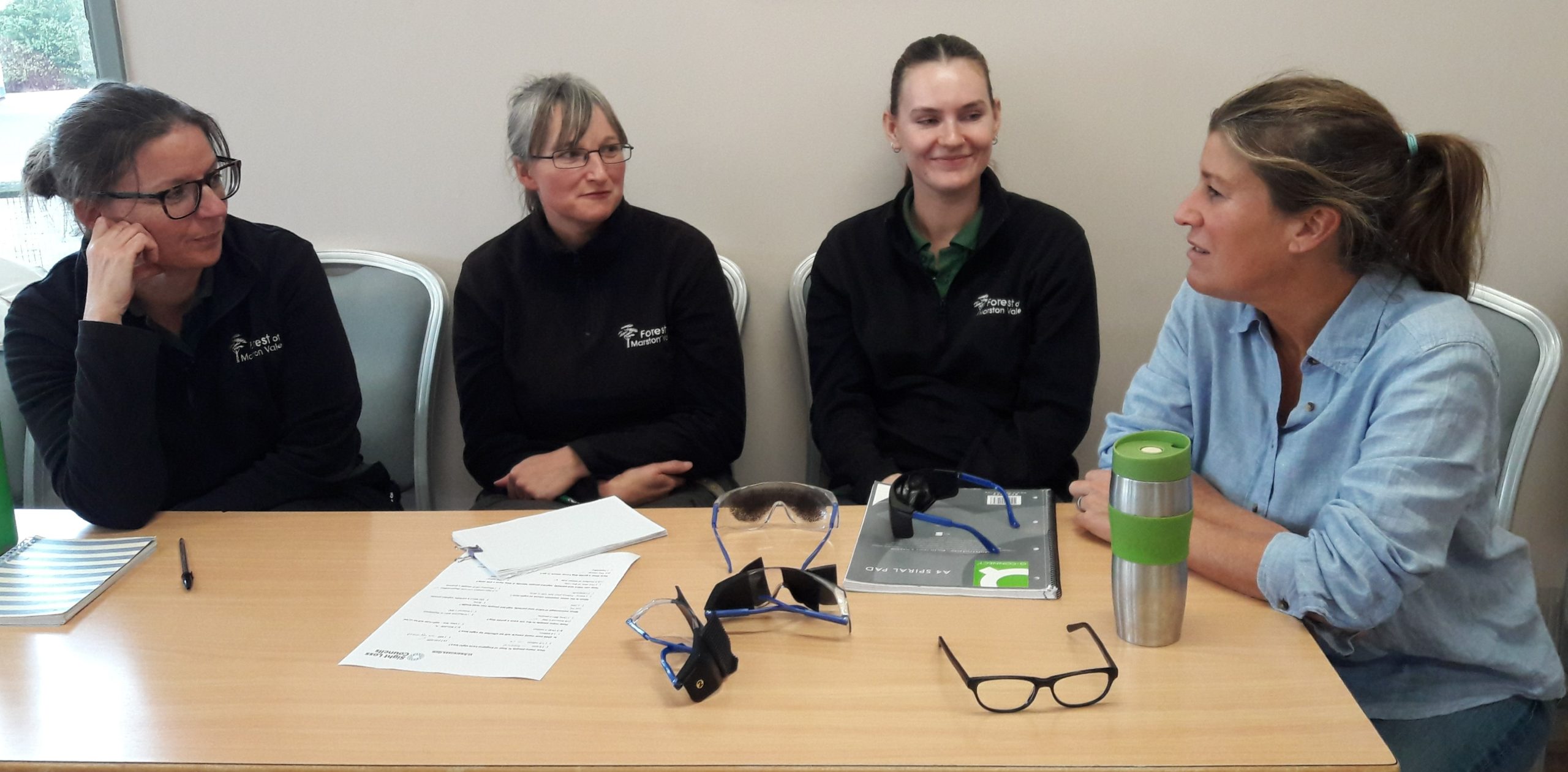 Marston Vale staff sitting around a table talking at the VI awareness training.