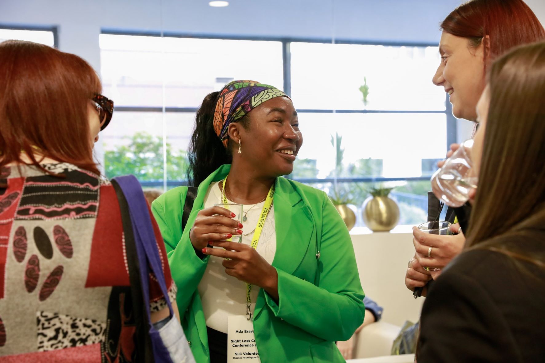 Close up of three ladies during a coffee break at the conference. They are smiling as they talk.