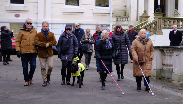 Councillors navigating the streets of Southport town centre wearing spectacles (sim specs), with Sight Loss Council members.