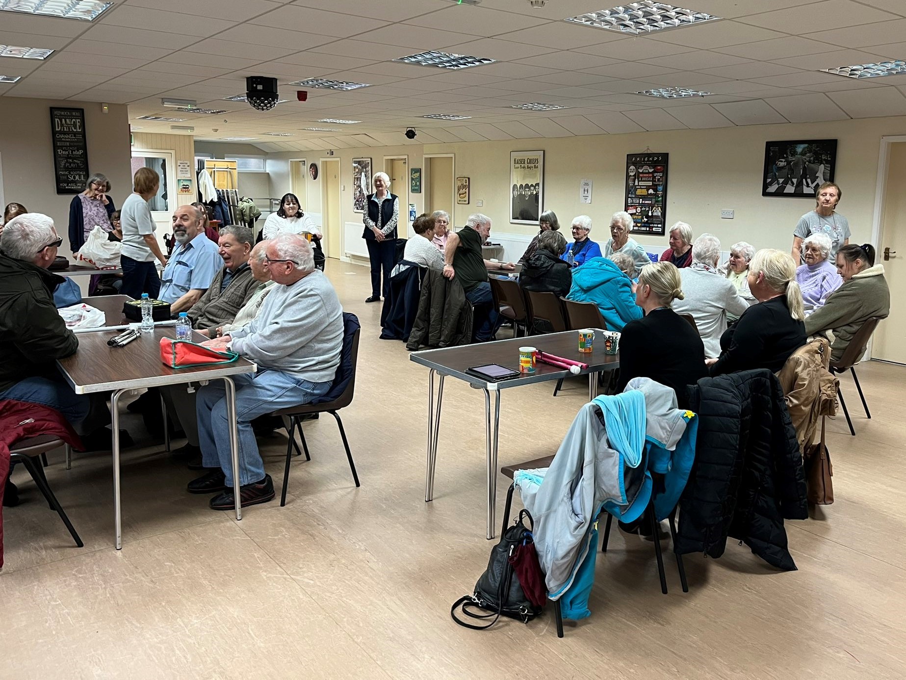 Around 30 blind and partially sighted people sat around tables at a Listening Month event in Halton