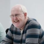 Martin Kearney, Tyne and Wear SLC member, is sat at a table with two other delegates. They are all relaxed and smiling.