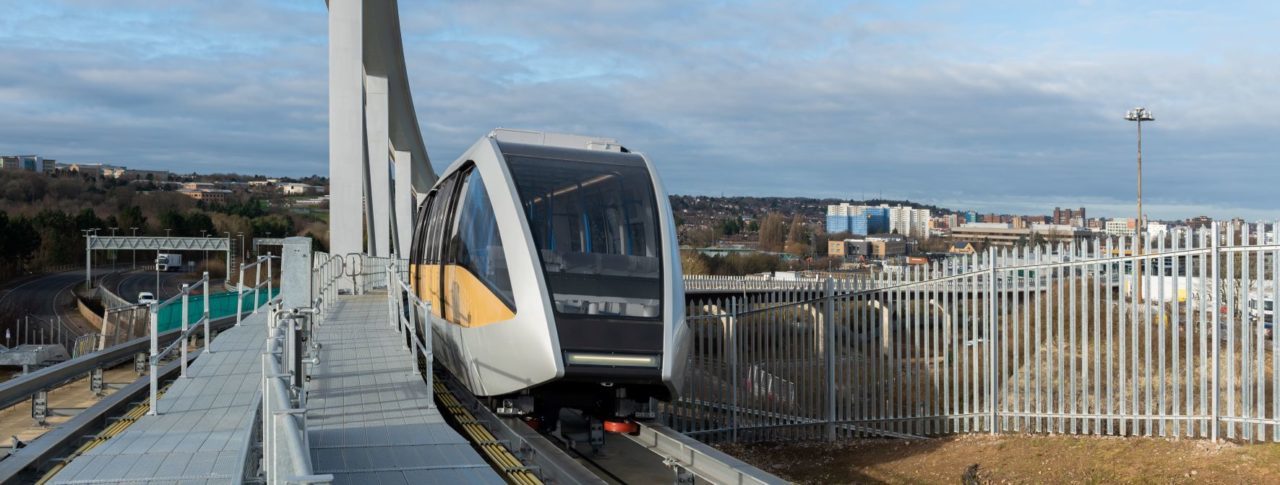 Image shows the Luton DART train driving alongside a platform.