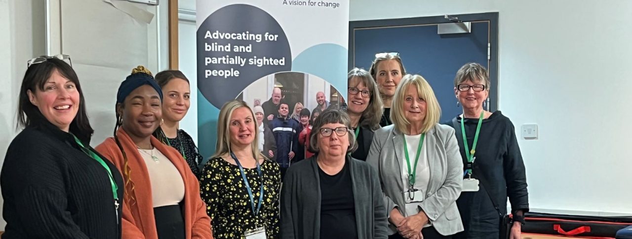 Group shot of Kelly, EM for Greater Manchester SLC, and Ada, SLC member. They are stood with staff members from John Lewis who participated in the VI awareness session.
